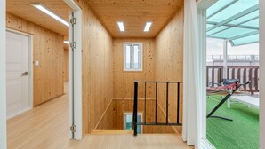 Ein Holzinnenraum mit einer Treppe zu einem Balkon.