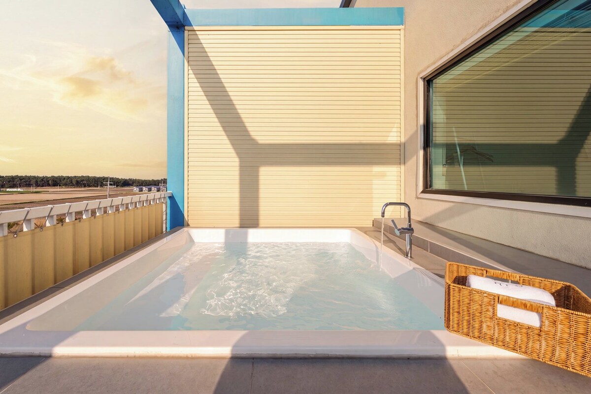 Un bain à remous sur un balcon avec vue sur un paysage lointain.