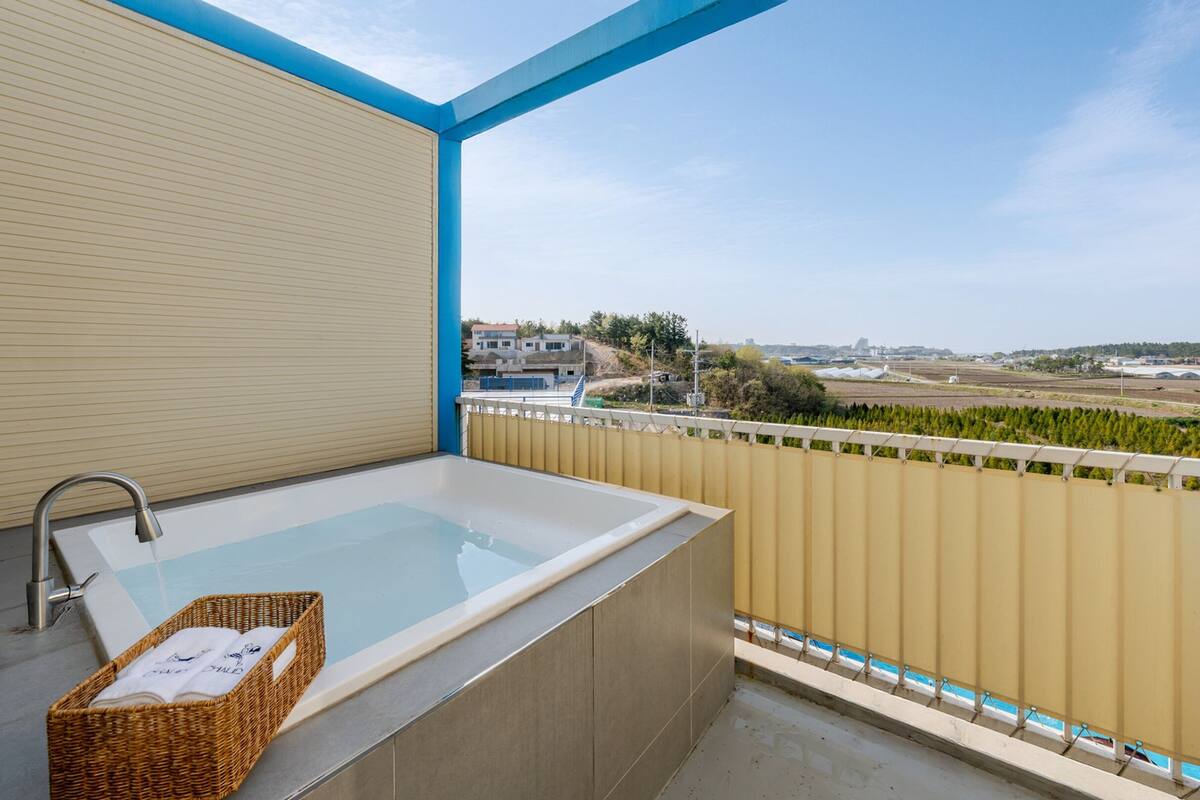 A balcony with a bathtub and a wicker basket.
