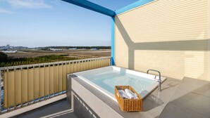 Ein Whirlpool auf einem Balkon mit Blick auf eine Landschaft.