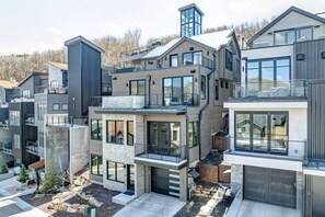 A modern multi-story residential building with balconies, large windows, and a stone foundation. - Abode at Powder King, ski-in/ski-out, hot tub, fire pit, PCMR (Park City)