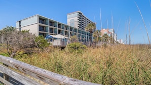 A coastal hotel with multiple balconies, a clock tower, and a beach view. - Oceanview Vibes! Compass Cove Studio Retreat (Myrtle Beach)