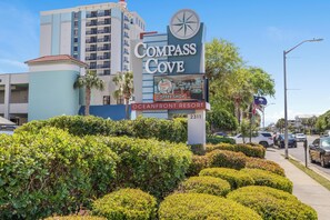 A sign for Compass Cove Oceanfront Resort with a coffee shop advertisement. - Oceanview Vibes! Compass Cove Studio Retreat (Myrtle Beach)