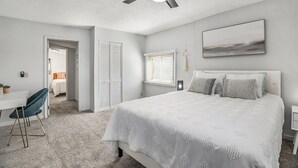 A bedroom with a bed, a desk, a chair, a ceiling fan, and a window. - Little Sand Cottage 3-bedroom cottage with AC, WiFi in serene Grant (Grant)