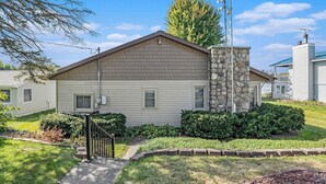 A single-story mobile home with a stone chimney, a small front porch, and a well-maintained lawn. - Little Sand Cottage 3-bedroom cottage with AC, WiFi in serene Grant (Grant)