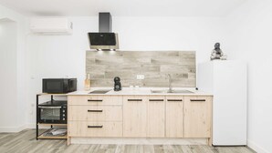 Une cuisine moderne avec des meubles en bois, un four à micro-ondes, un grille-pain et un four encastré.