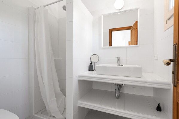 Une salle de bain moderne avec une douche, un lavabo et un miroir.