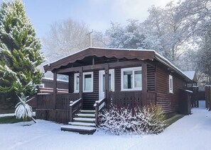 Une cabane en bois avec un porche, des marches et une plaque portant le numéro « 9 ».