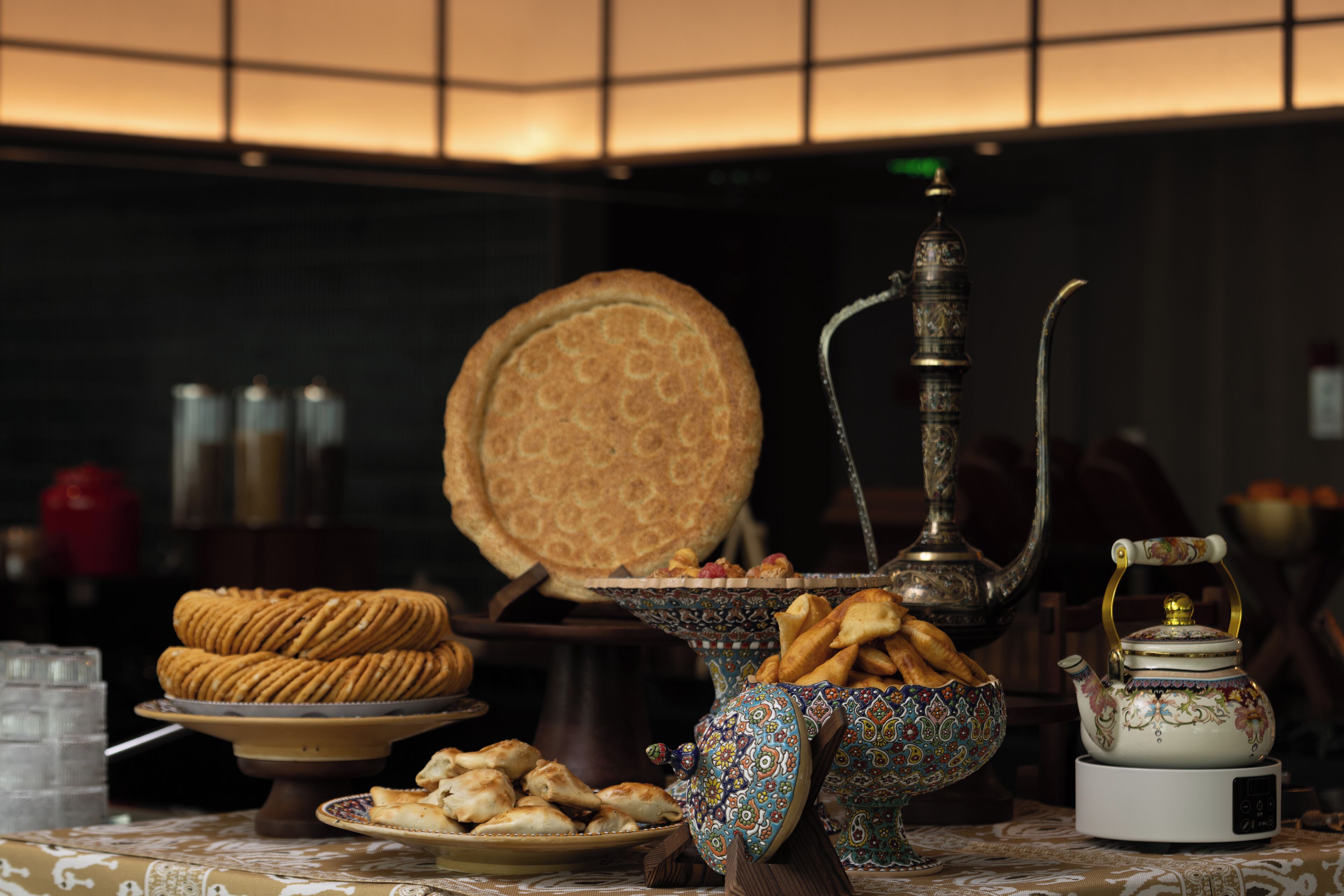 A table with pastries, a teapot, and a hookah.