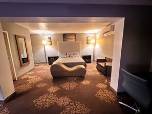 A hotel room with a large bed, two bedside tables, a chair, a desk, and a flat-screen TV. - Hotel Dulce Maria (Tijuana)