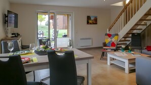 Un espace repas comprenant une table, des chaises et une vue sur l’extérieur.