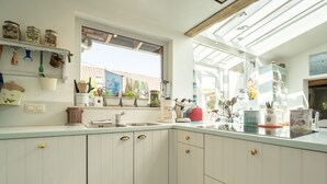 A kitchen with white cabinets, a window, and a countertop with various items.
