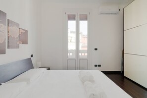 Une chambre d’hôtel avec un lit, une armoire, une porte et un climatiseur fixé au mur.
