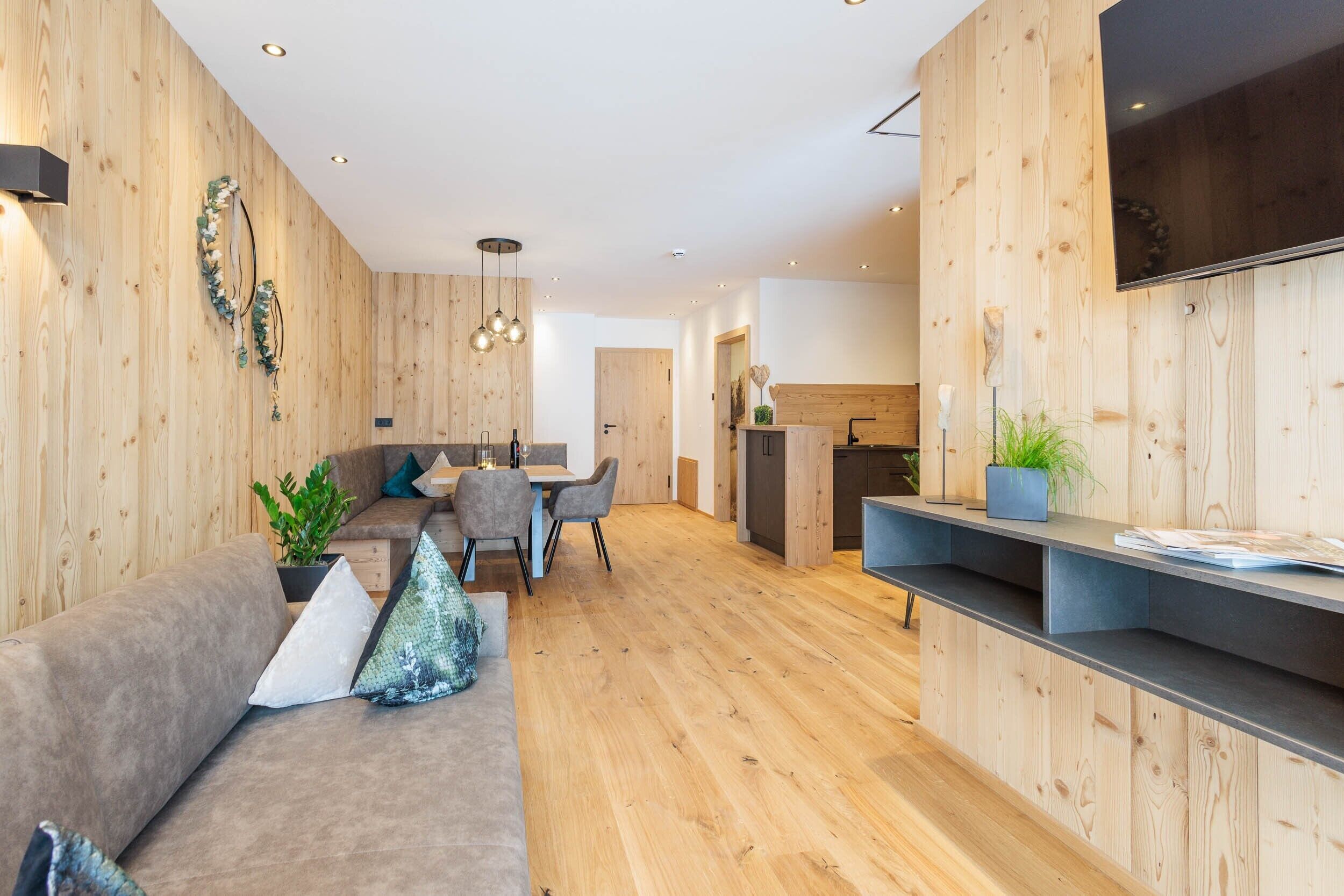Un interno moderno con pareti in legno, una zona pranzo e una cucina.