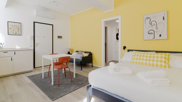 Une chambre d’hôtel moderne, équipée d’un lit, d’un bureau et d’une chaise.