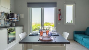 A modern kitchen with a dining area, a sofa, and a fire extinguisher.