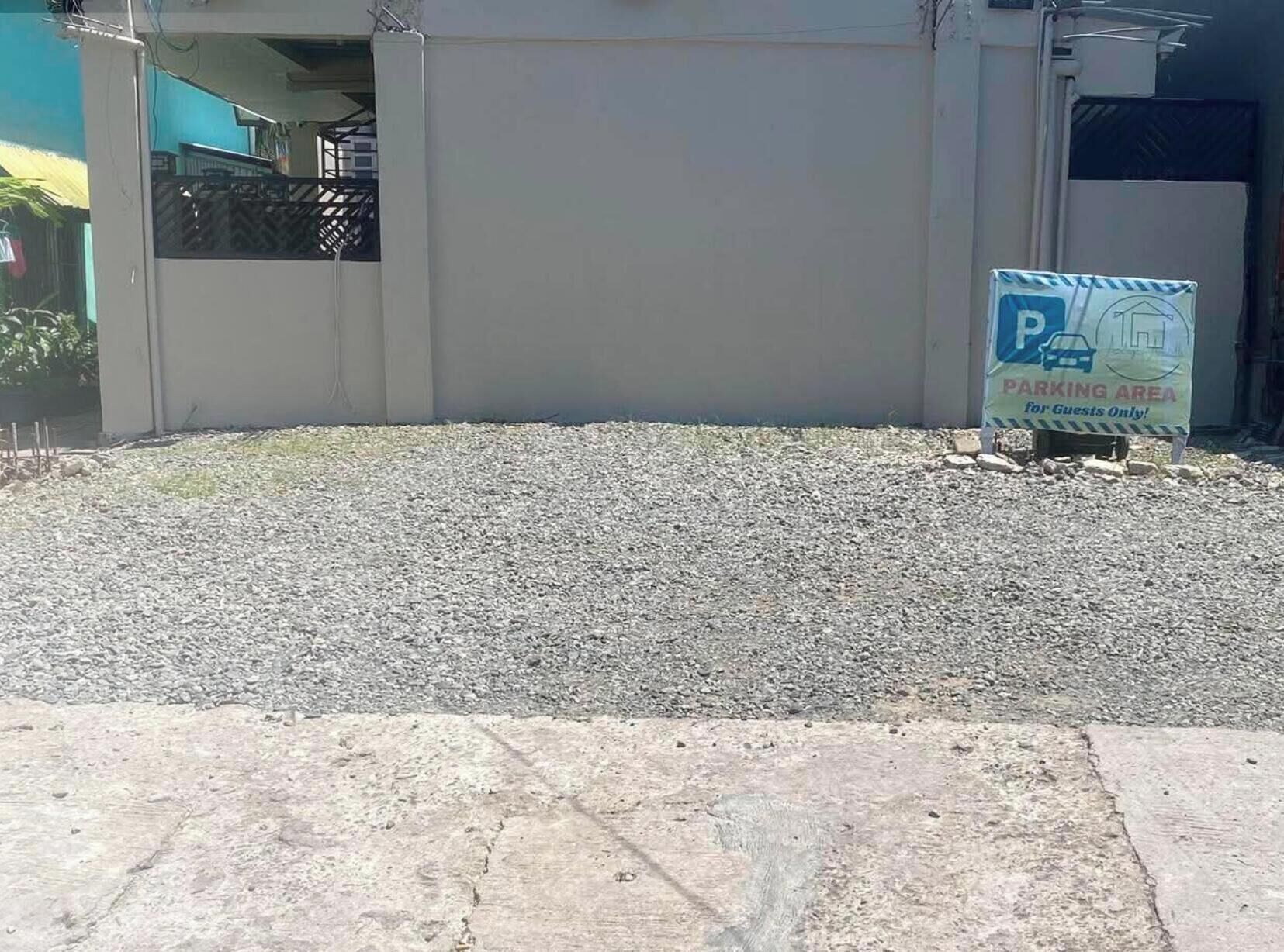 A gravel parking area with a sign indicating it is a parking area for guests only.