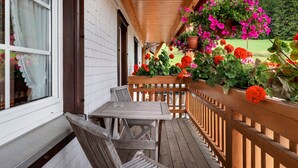 A wooden deck with a table and chairs, surrounded by a wooden railing. - Room 'Nr 7' with Mountain View, Shared Terrace and Wi-Fi (Titisee-Neustadt)