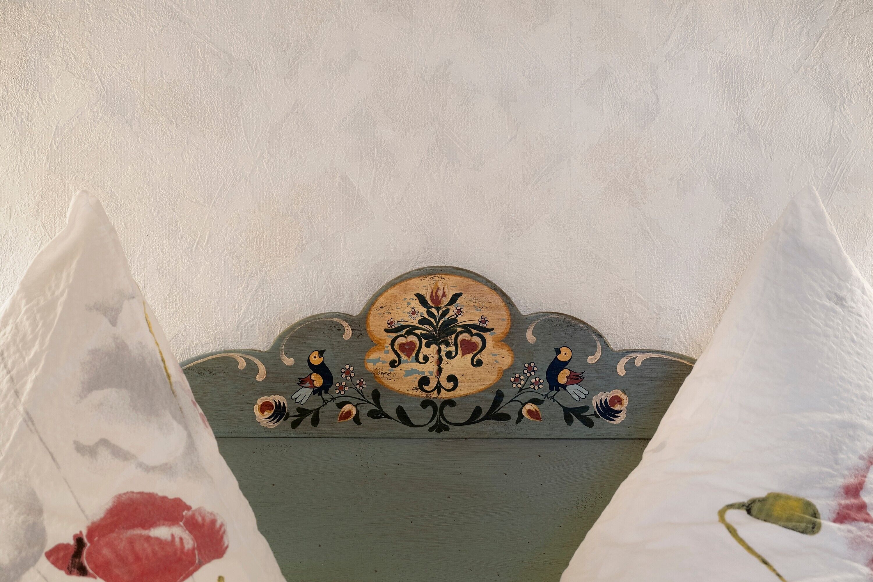Eine Wand mit einem floralen Dekor und einem zentralen Wappen.