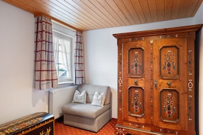A room with a window, a sofa, and a wooden cabinet.