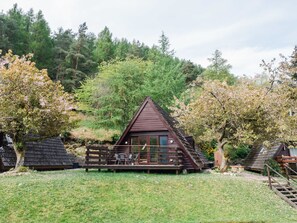 A cabin with a triangular roof, surrounded by trees and a grassy area. - Heron Lodge by Interhome (Invergarry)