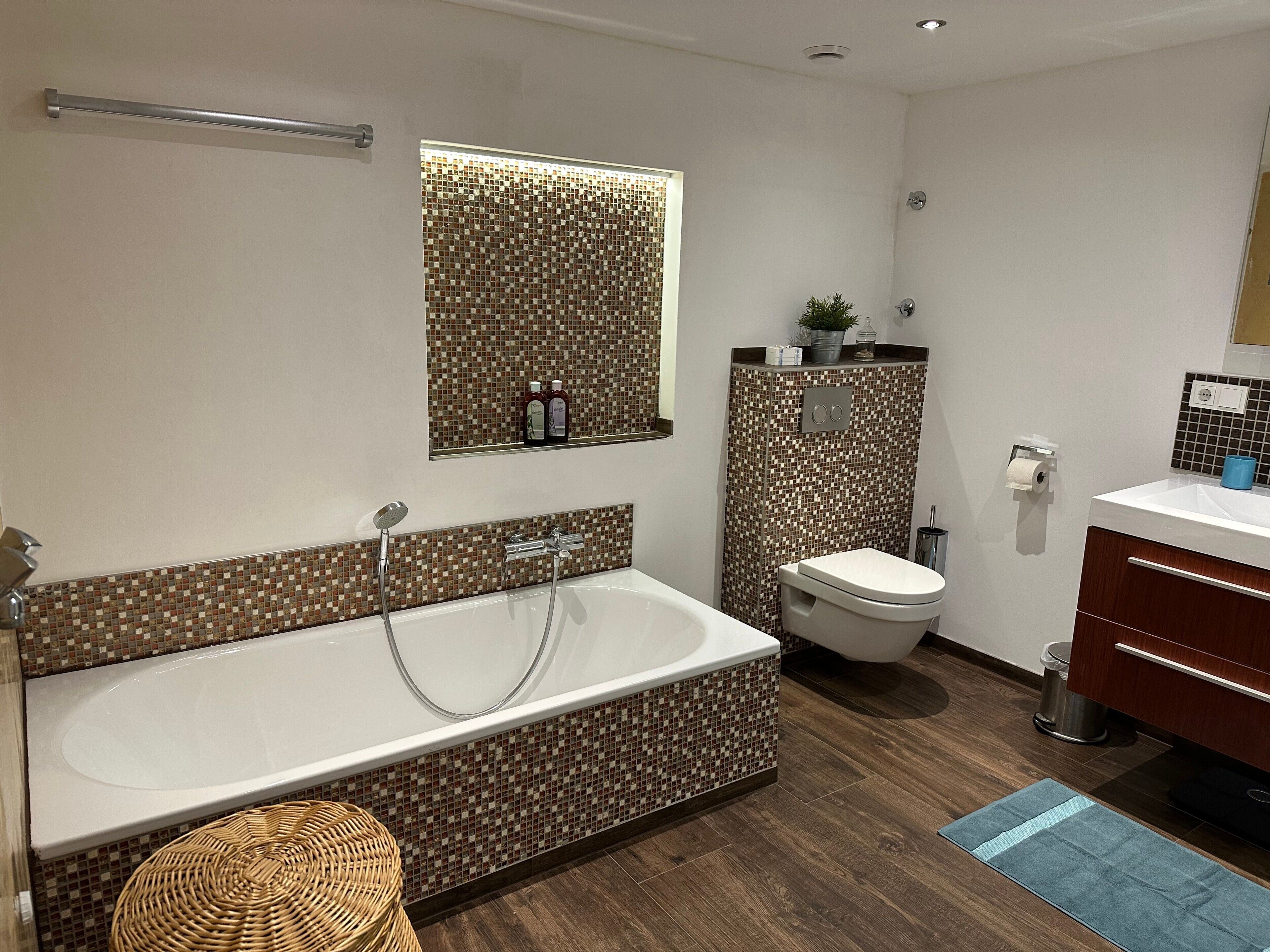 Uma casa de banho moderna com banheira, sanita e lavatório.