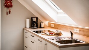 Eine Küche mit Oberlicht, einer Kaffeemaschine, einem Toaster und einem Brot auf der Arbeitsfläche.