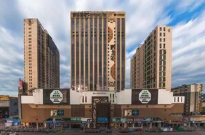 Un immeuble à plusieurs étages, doté d’un élément vertical central et de deux ailes symétriques.
