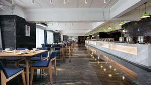 A modern restaurant with a long counter, blue chairs, and a polished floor. - Campanile Jingdezhen Mperial Kiln Hotel (Jingdezhen)