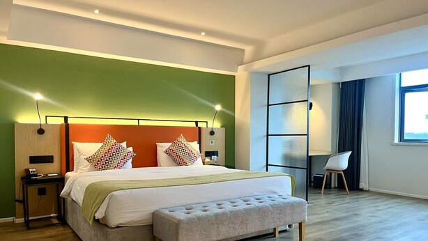 A modern hotel room with a large bed, a bench, a desk, and a chair. - Campanile Jingdezhen Mperial Kiln Hotel (Jingdezhen)