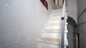 A narrow stairway with white walls and a red sign. - GuestHost - Charming apartment of about 35 sqm, perfect for 2 people, located on the second floor of a building without a lift.The property is located in the heart of the historic center of Monopoli, a few steps from the splendid Cathedral of Santa Maria (Monopoli)