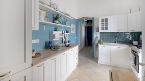 A modern kitchen with white cabinets, blue walls, and a wooden countertop. - GuestHost - Charming apartment of about 35 sqm, perfect for 2 people, located on the second floor of a building without a lift.The property is located in the heart of the historic center of Monopoli, a few steps from the splendid Cathedral of Santa Maria (Monopoli)