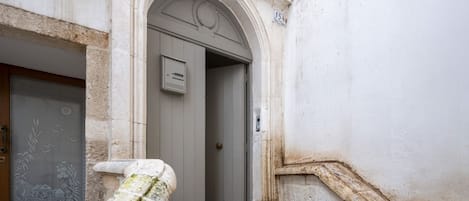 A building entrance with a stone staircase leading up to a door.