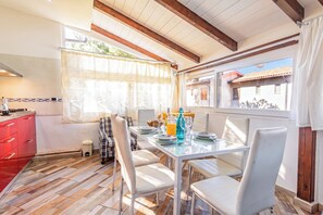 A dining area with a glass table, white chairs, and a view of the outside. - La Rosa dei Venti, Sorso, Italy (Sorso)