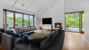 A spacious living room with a large sectional sofa, a flat-screen TV, and a fireplace. - Cozy home in Vejby with sauna (Vejby)