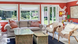 A cozy living room with a sofa, two wicker side tables, and a chair. - 4 bedroom awesome home in Vejby (Vejby)