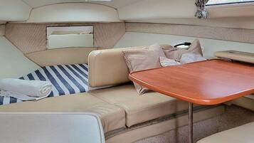 Un interior compacto y bien equipado, con una zona de estar acolchada, una mesita y un espejo.