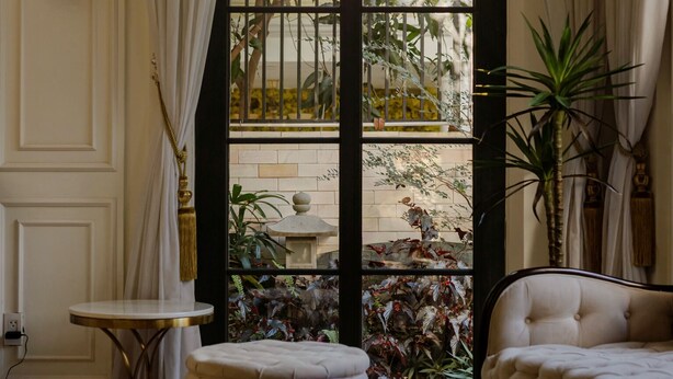 A room with a large arched window, a white sofa, a round table, and a potted plant. - S Home Apartment by DDH (Ho Chi Minh City)