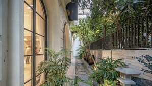 A narrow pathway with stone steps, surrounded by lush greenery and a stone lantern. - S Home Apartment by DDH (Ho Chi Minh City)
