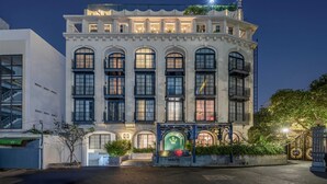 A multi-story building with a prominent entrance, large windows, and a balcony on the upper floor. - S Home Apartment by DDH (Ho Chi Minh City)