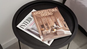 Una revista titulada "Arquitectura Diseño" sobre una bandeja negra.
