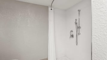 Un baño moderno con ducha, inodoro y suelo de baldosas hexagonales.