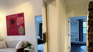 Ein modernes Interieur mit schwarzem Boden, weißen Wänden, einem roten abstrakten Gemälde und einem weißen Sofa.