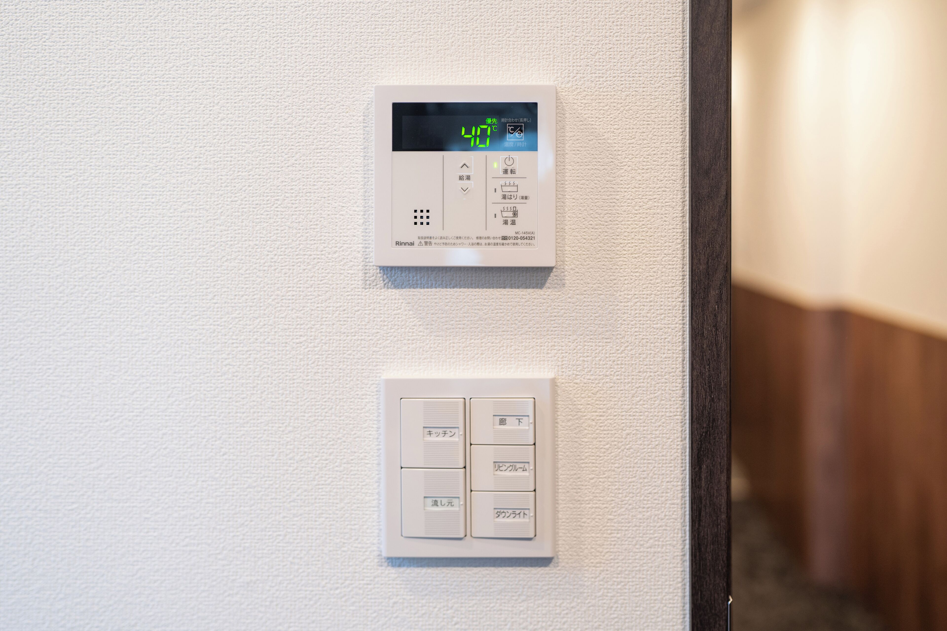 A thermostat and control panel on a wall.