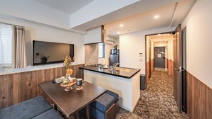 A compact hotel room with a dining area, kitchenette, and a hallway leading to another room. - Apartment Hotel 11 Abeno (Osaka)