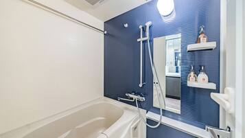 Habitación triple, para no fumadores, balcón | Baño | Regadera, secadora de cabello, pantuflas, toallas