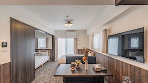 A hotel room with a bed, a desk with a vase, a coffee maker, and a flat-screen TV. - Apartment Hotel 11 Abeno (Osaka)
