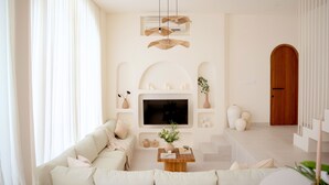 A modern living room with a sofa, TV, and decorative items.