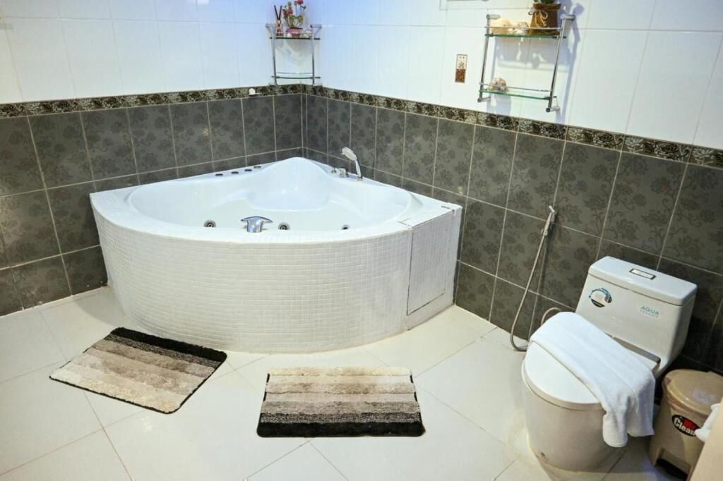 A bathroom with a large bathtub, a toilet, and a shower.