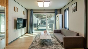 Un salon moderne avec un canapé, une table basse et un téléviseur fixé au mur.
